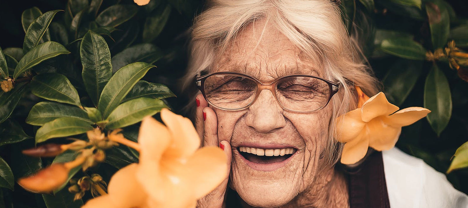 mature lady smiling with orange flowers