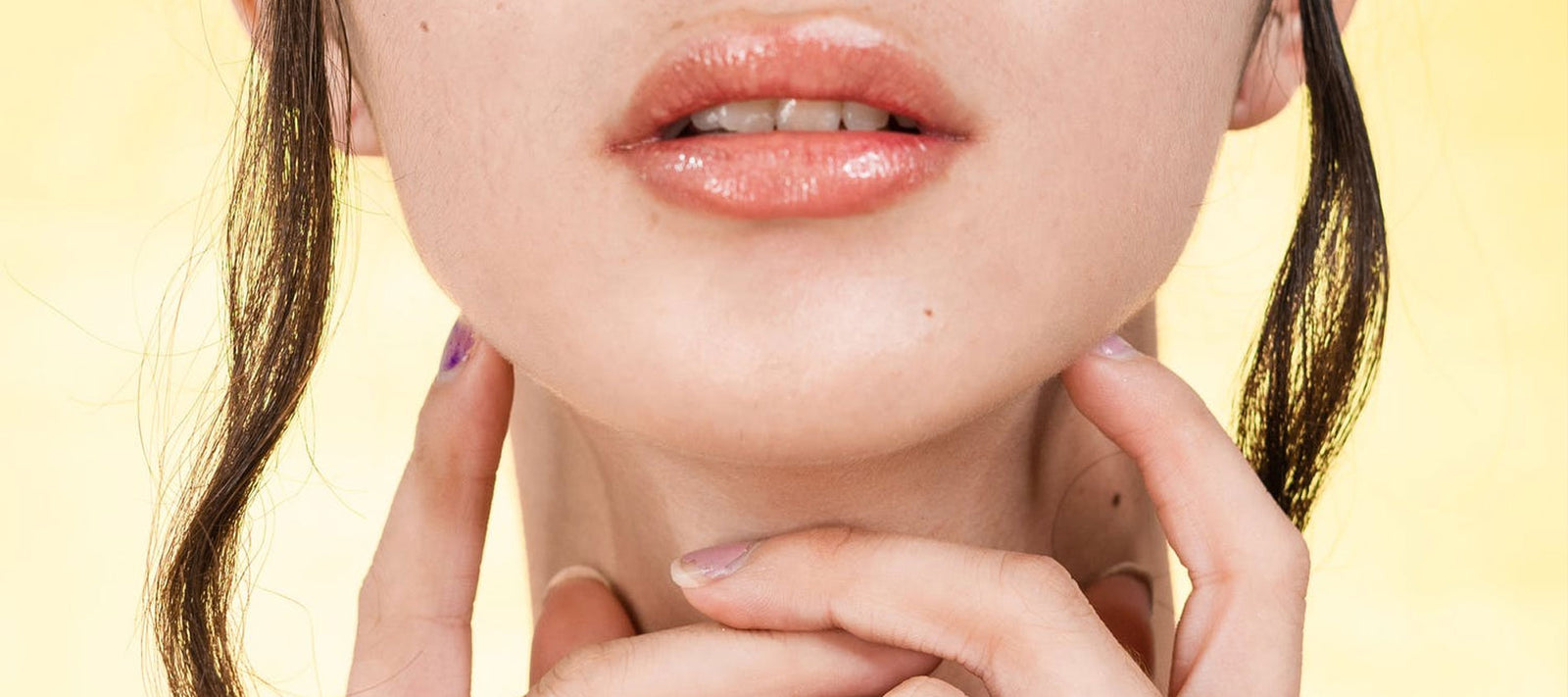 Girl holding neck half face with yellow background