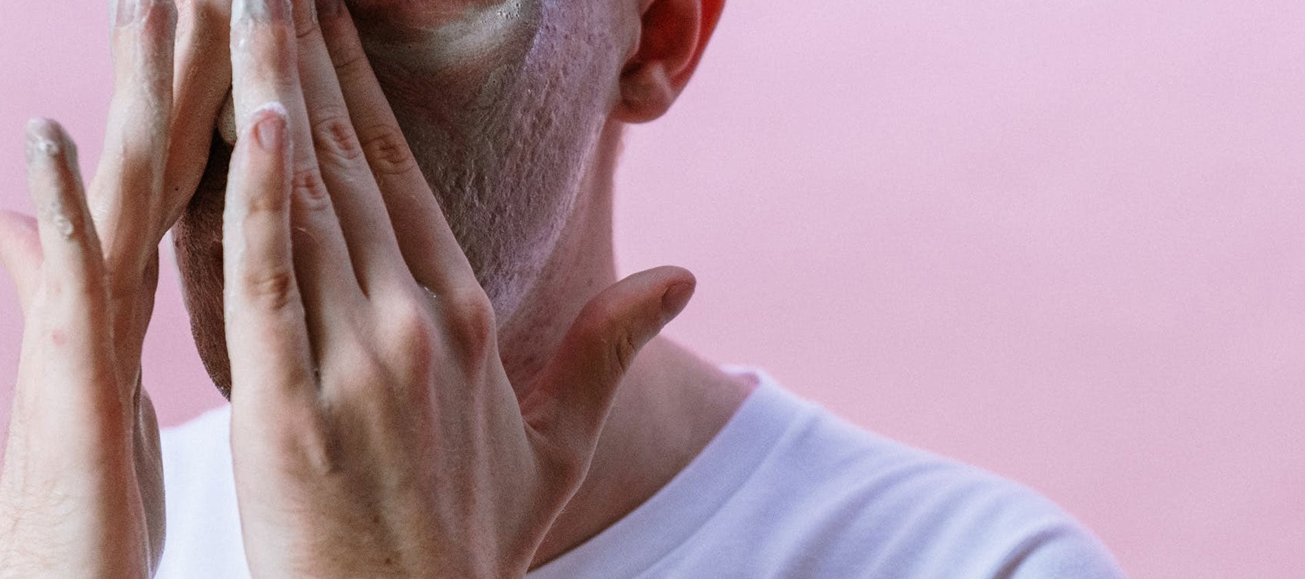 guy washing face pink background